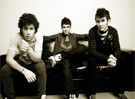 Jonas Brothers posando en un sofá 